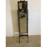A 20th century cheval mirror. With brass finials. H:160cm
