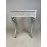 A Victorian cast iron console stand with original white paint decorated with floral swags and