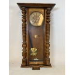 A walnut veneered Vienna style wall clock with pendulum. W:42cm x D:20cm x H:96cm