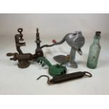 A collection of vintage mincers, scales and a glass bottle.
