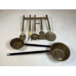 Vintage brass kitchenalia, a brass hanging rail with five utensils and two small brass pans with