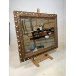 A decorative gilt painted mirror with bevelled edge. W:83cm x H:68cm