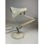 An cream angle poise lamp on circular base.