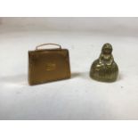 A mascot handbag shaped compact with musical box together with a figural brass bell
