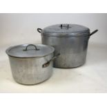 Two large army style stainless steel cooking pots with lids.