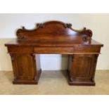 A large Victorian mahogany sideboard chiffonier with ornate scroll top above three drawers, two