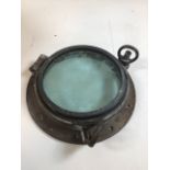 A vintage brass ships porthole. Diameter of glass 22cm, overall width 33cm. Hinge engraved with