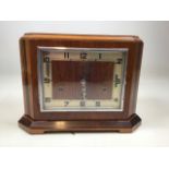 A 1930s square mantle multi chime clock. With painted numbers and ornate metal hands. With key and