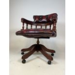 An ox blood red leather captain office swivel chair. On castors.