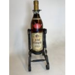 A 3 litre bottle of Weinbrand VSOP bandy on wrought iron stand. Stand H:37cm