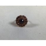 A yellow metal dress ring with garnet in flower design - 1 stone missing. Ring size P