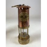 A Copper and brass miners lamp with printed leaflet and original packaging tube. H:26cm