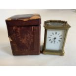 A small brass carriage clock with four bevelled glass side panels and an oval to top. With brass key