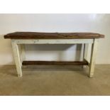 A rustic natural wood side table with distressed painted base and stretcher bar. (A.f one side