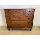 A Victorian mahogany chest of drawers with brass handle to central drawer flanked by two short