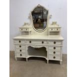 A Maple and Co decorative dressing table with nine drawers to base, shield shaped swing mirror and