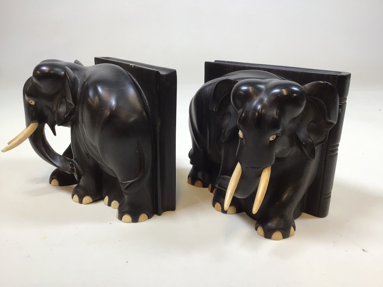 A pair of heavy carved ebony elephant book ends W:16cm x H:15cm