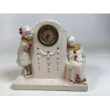 A 1930s plaster clock with boy and girl Pierrot style clowns. Untested W:23cm x D:18cm x H:21cm