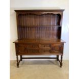 An early 20th century oak dresser with plate rack to top, base with two large central drawers