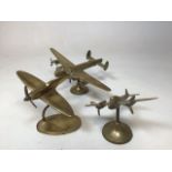 Three brass airplanes with rotating propellers. Includes a Lancaster bomber, a Spitfire and another.