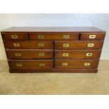 A long chest of drawers with campaign style brass handles and corners, brass handles to the