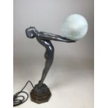 An Art Deco style figural lamp of a nude holding a glass ball. Cast aluminium on stepped plinth.
