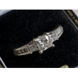 A 14ct white gold diamond trilogy ring. Approx 0.25ct and further diamonds on shoulders. Marked past