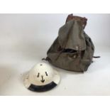 A World War ll metal helmet with painted anchor together with a World War II military Cresta