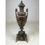 A large metal urn on marble plinth with gilt metal feet and mount. W:17cm x D:14cm x H:56cm