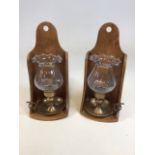 A pair of pine wall brackets with glass and brass candle holders W:16cm x H:35cm