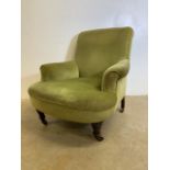 A Victorian Howard style arm chair in green draylon upholstery. With ceramic and brass castors. Seat