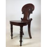 A George IV style mahogany hall chair. Rounded seat and carved back on turned legs W:44cm x D:37cm x