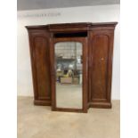A Victorian Mahogany break front wardrobe with large mirrored door to chest and linen slides flanked