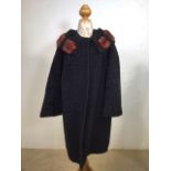 A black astrakhan fur trimmed coat circa 1950s with butterfly patterned lining