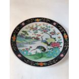 A large oriental charger hand decorated with storks. Character stamp verso H:37cm
