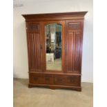 An Art Nouveau mahogany wardrobe with large central mirror, flanked by doors, two I drawers to base.