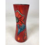 A Poole pottery vase designed by Andrew Tanner in red and orange with floral design W:10cm x H:24cm