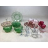 A green cut glass mid century dessert set together with a pink opaque glass dressing table set, a