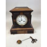 An early twentieth century mantle clock with striking mechanism and applied carved wood decorative