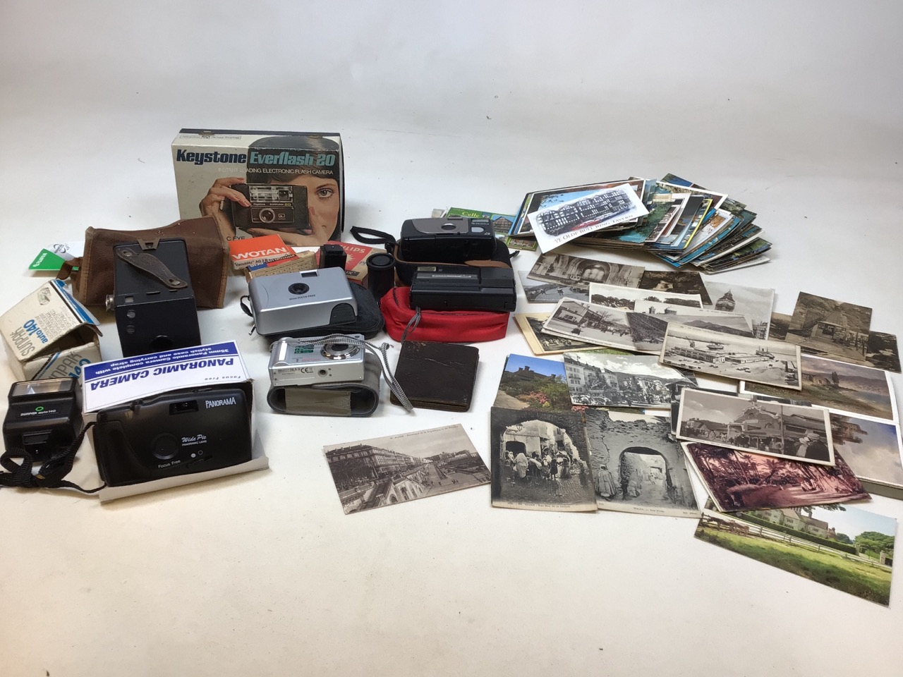 A quantity of cameras and accessories also with vintage postcard some early images of Algiers