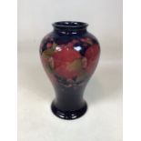 A Moorcroft Pomegranate vase, shape 65, on blue ground, impressed Moorcroft and signed in green W