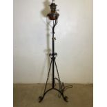 An adjustable converted copper and brass oil lamp on iron tripod stand. Approx H:160cm