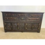 A Large Victorian heavily carved sideboard with brass handles, with six drawers above cupboards. W: