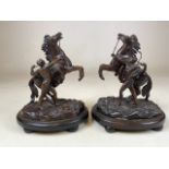 A Pair of 20th century spelter Marley horses on wooden oval bases with small bun feet. H:23cm