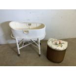 A mid century Lloyd loom style crib with removable basket and wheeled base together with a gold