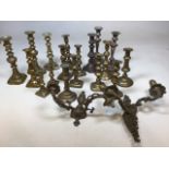 A quantity of copper and brass candlesticks also with a pair of ornate brass effect wall sconces H: