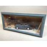 A diorama of a Morris Minor in a garage W:28cm x H:14cm