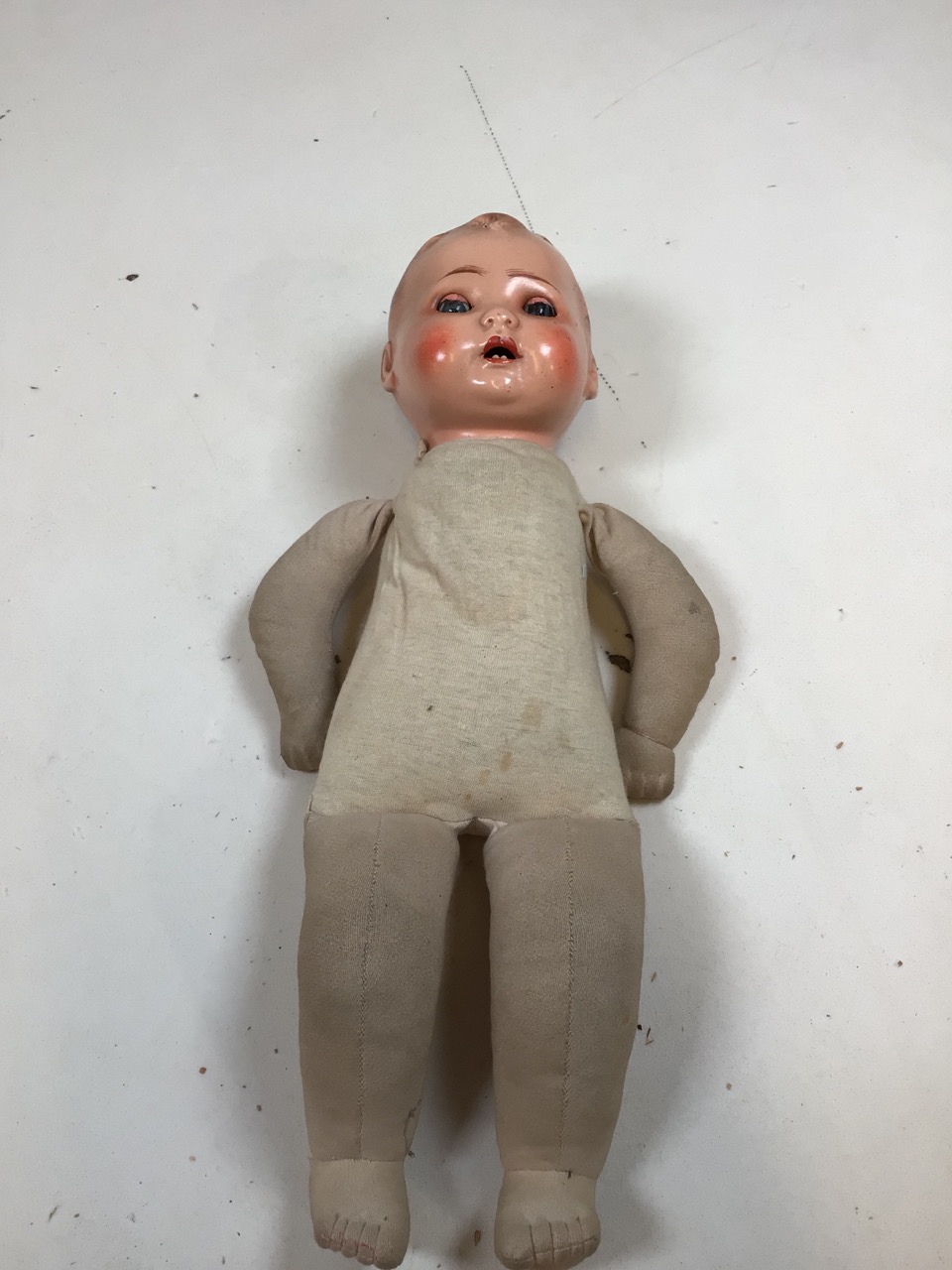 Vintage doll with glass eyes and teeth with soft fabric body. 17 inches . Hole to front of head