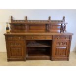 A large Victorian walnut sideboard with galleried top with turned supports the base with three