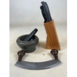 A pestle and mortar, knives and a Mazzaluna herb chopping knife.